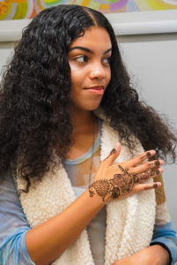 Young girl with hand painted with henna